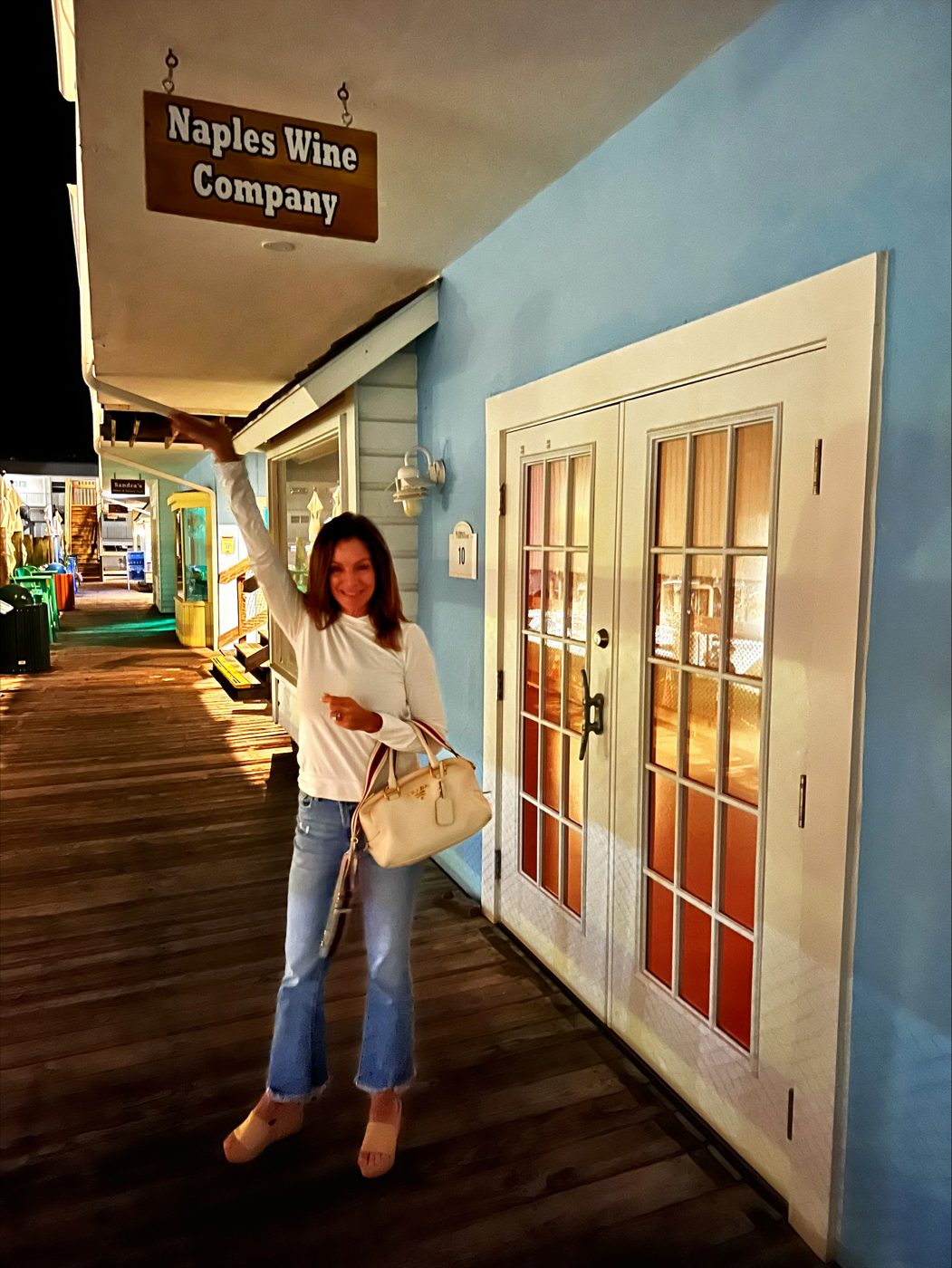 Naples Wine Company sign above its French doors on the Dockside boardwalk